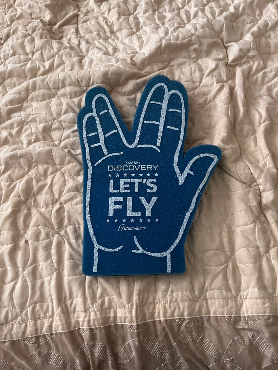 A foam finger/hand in the style of a Vulcan salute. On it, it says “Star Trek: Discovery | Let’s Fly”.