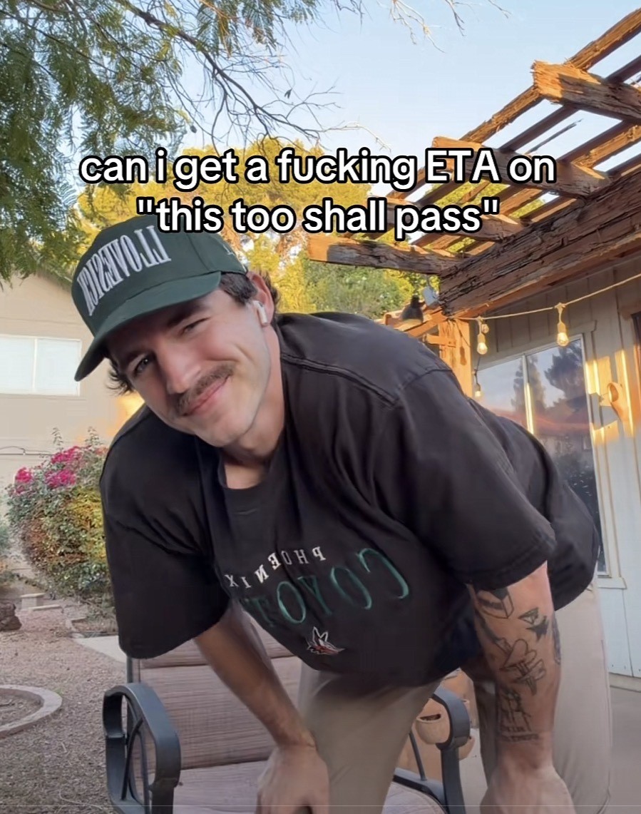 Man looking into the camera with the caption: can iget a fucking ETA on
"this too shall pass"